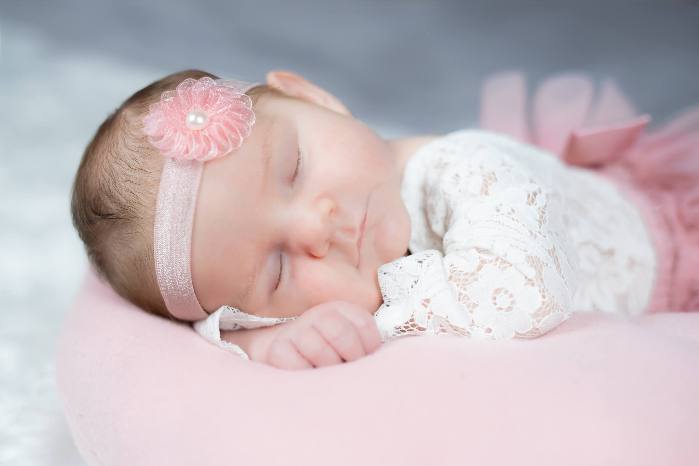Neugeborenes Baby in Kleid beim Fotoshooting