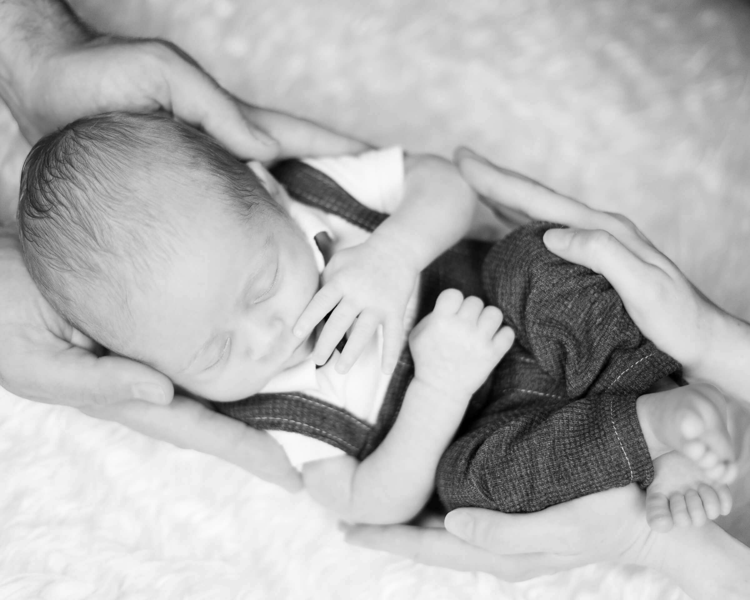 Neugeborenes wird von Mama und Papa gehalten