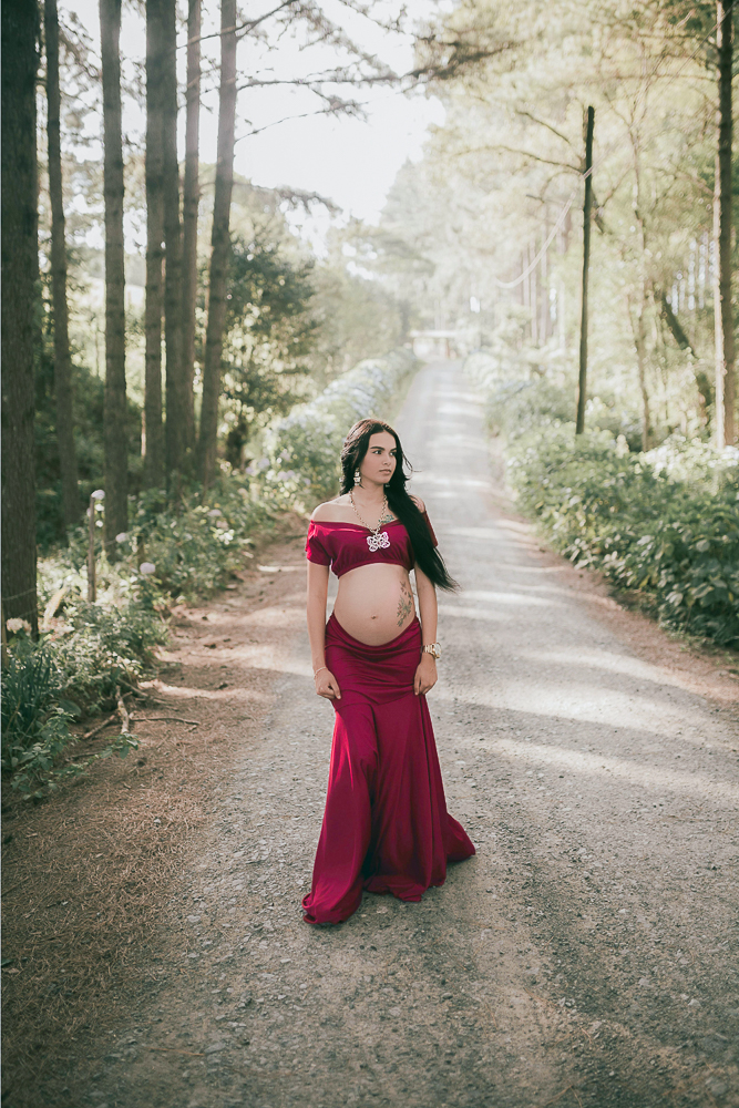Frau mit Babybauch im zweiteiligem Babybauchkleid während eines Babybauch-Shootings in der Natur in Wolfsburg