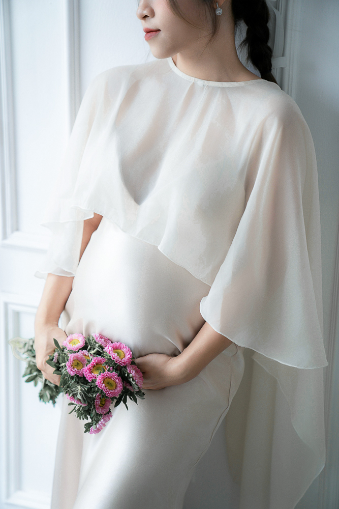 Schwangere Frau mit Babybauch im Babybauchkleid bzw. Umstandsbrautmode